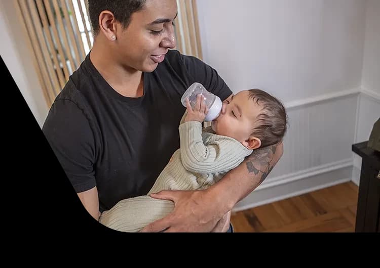 padre sosteniendo a su bebé mientras le daba el biberón