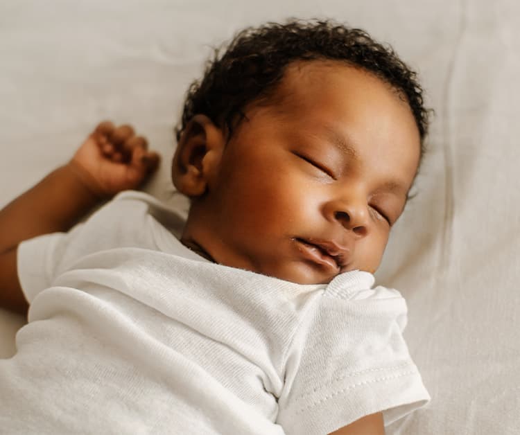 Close up of a baby sleeping on their back