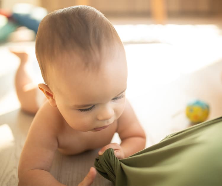 Bebé agarrando la camisa de su madre