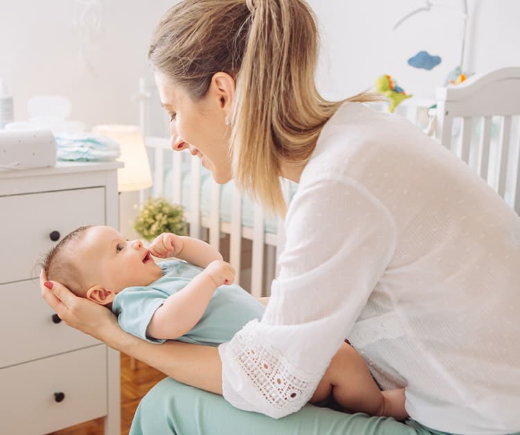 Mom holding baby in nursery