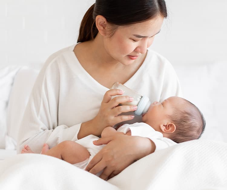 Mom cradling baby and bottle feeding