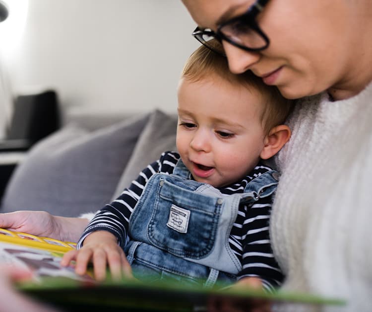Mom reading a book to her toddler son