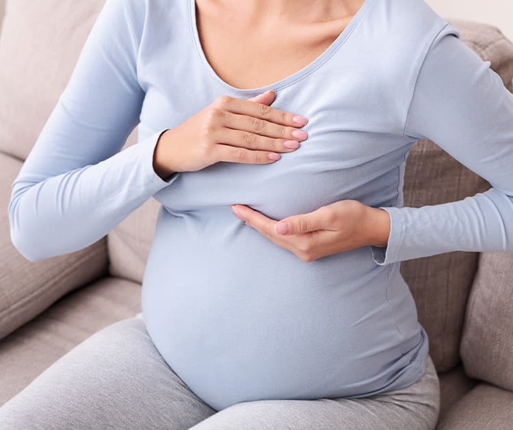 Pregnant woman pressing on breast