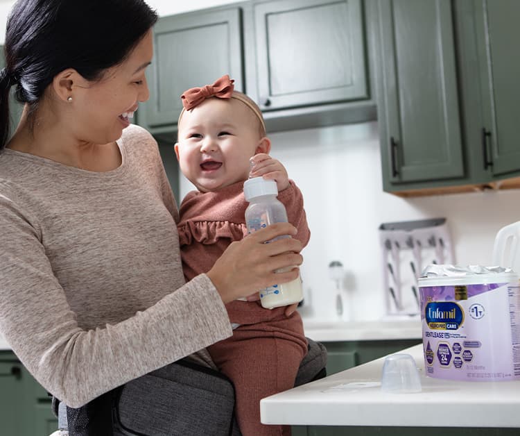 Mom holding excited baby and laughing