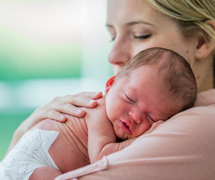 Mom snuggling newborn baby