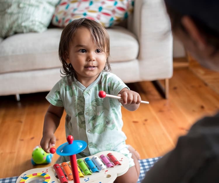 Toddler playing with xylophone