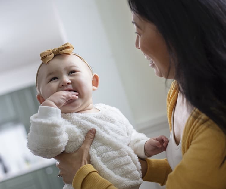 Mom holding smiling baby