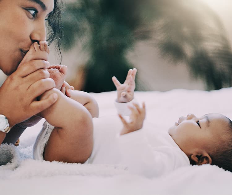 Madre besando los pies de su bebé