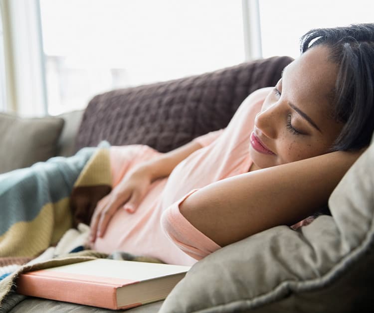Pregnant woman laying on the couch on her side