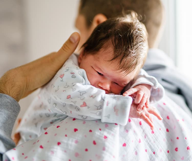 Dad burping newborn baby