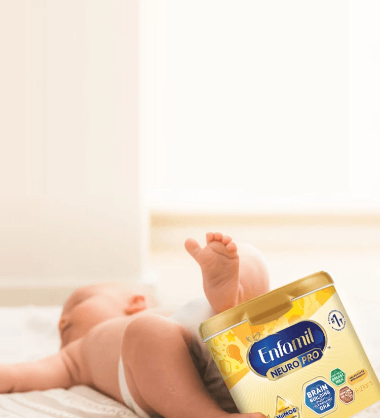 Baby holding a enfamil container with his feet