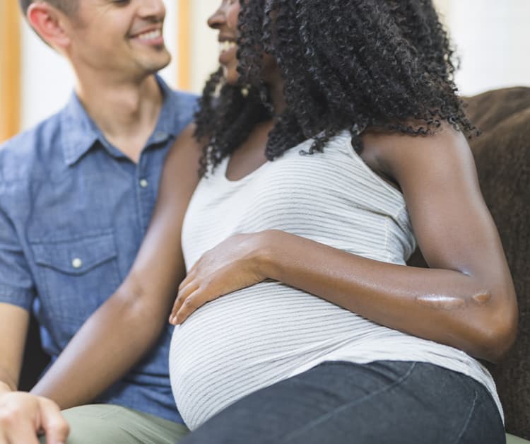 Expecting couple sitting on the couch together