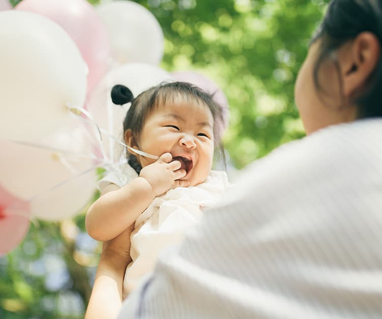 baby holding balloons