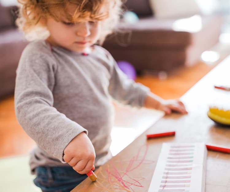 Toddler marking on coffee table with crayons