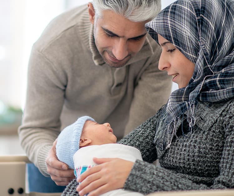 Dad and mom looking lovingly at new baby