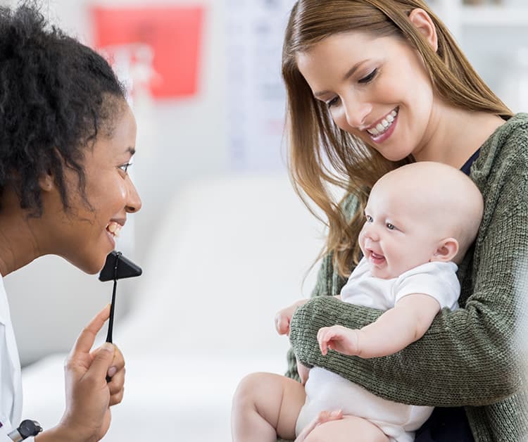 Mom holding her new baby at pediatrician appointment