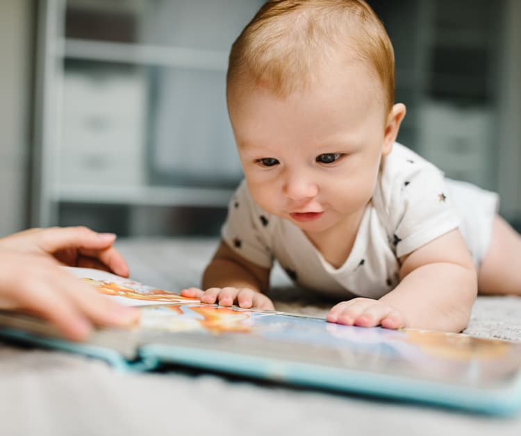 Baby on their tummy looking at a book