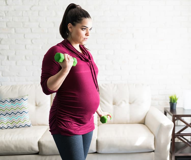 Pregnant woman lifting light weights
