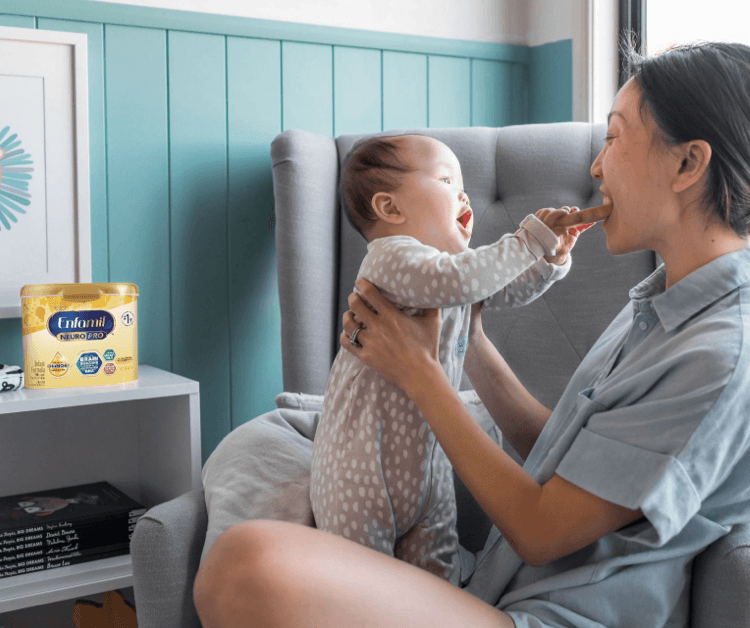 Happy baby feeding mom a piece of bread