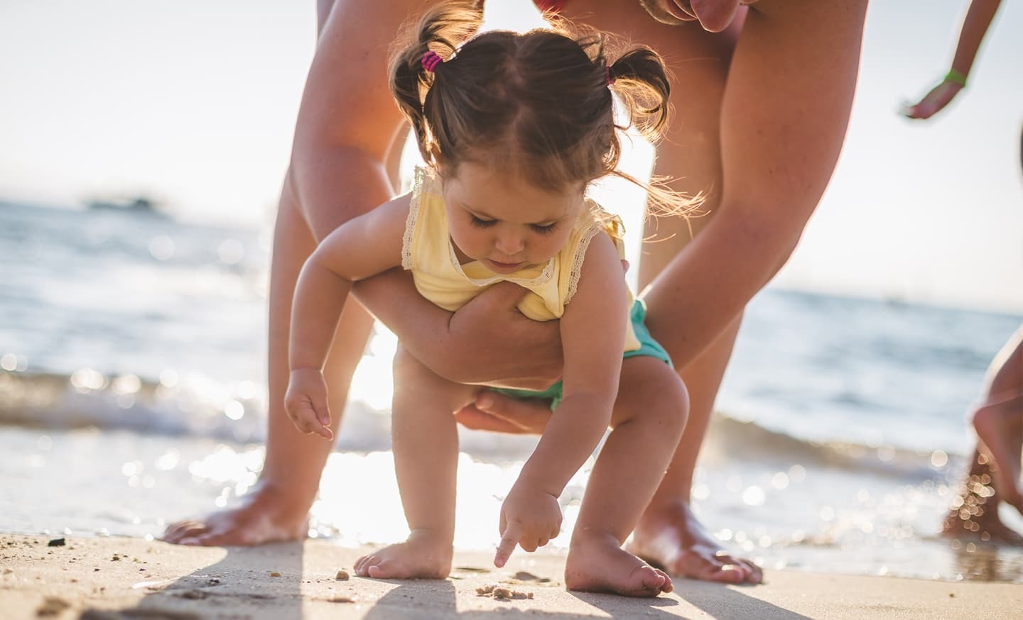 Niña jugando en la arena con su padre