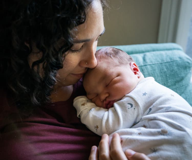 Mamá sosteniendo al bebé dormido