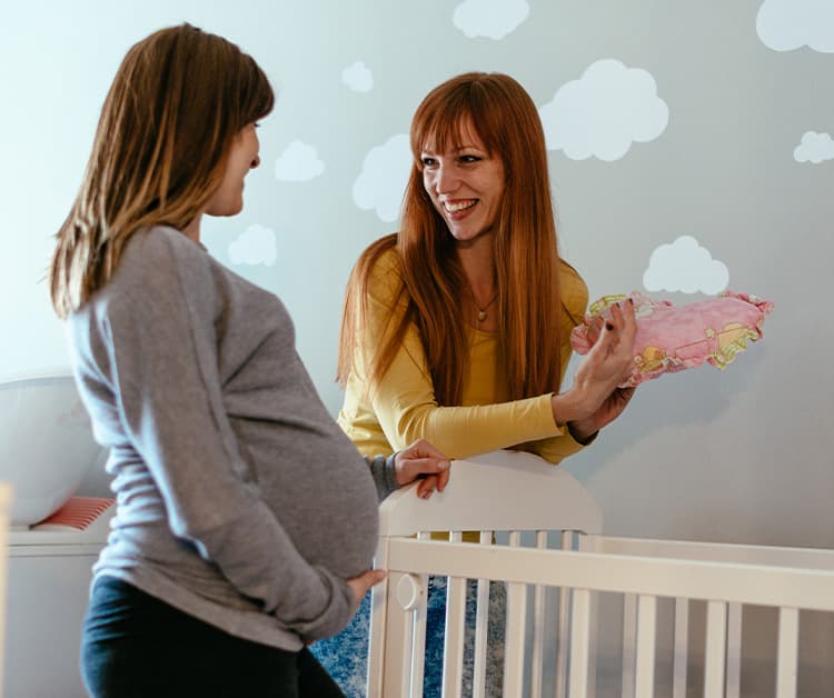 Expecting mom and doula talking in baby's nursery