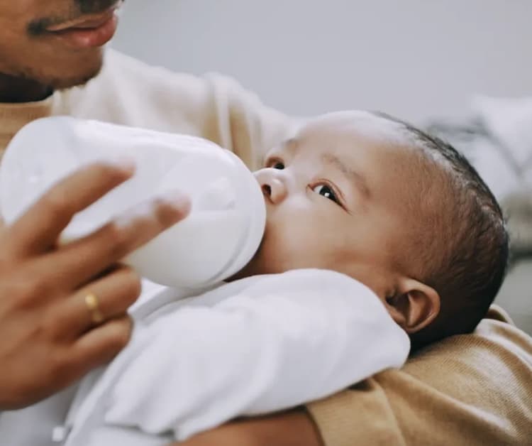Papá alimentando al bebé con un biberón