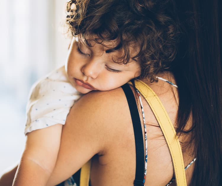 Mom holding sleeping toddler