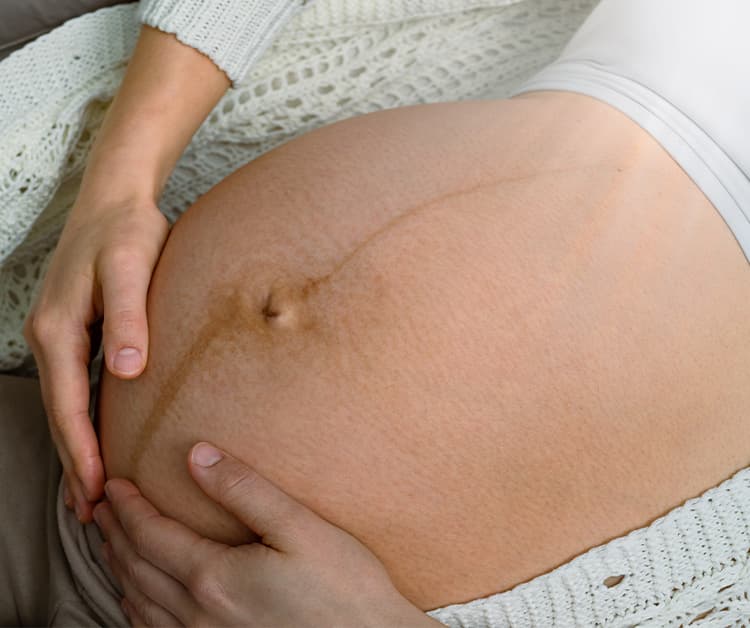 Pregnant woman showing her friend her ultrasound picture