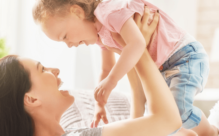Mom lifting up happy toddler in the air