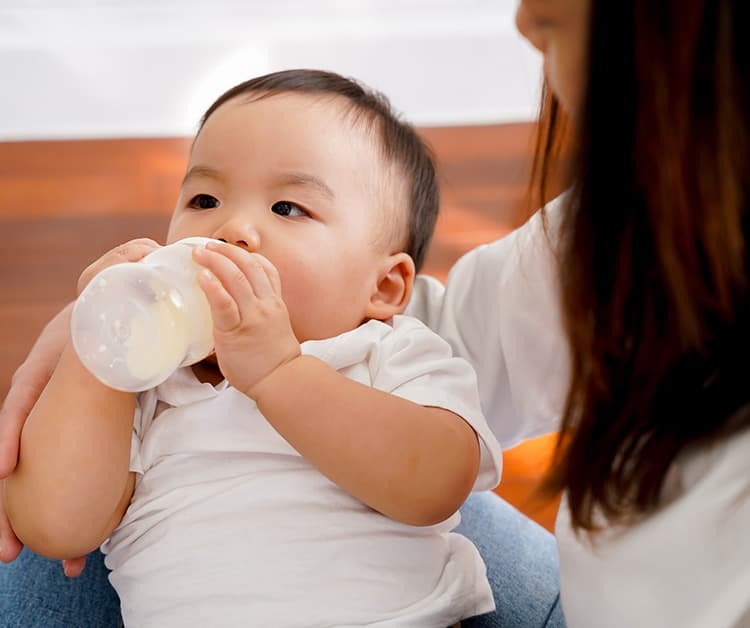 Mom holding baby as they drink a bottle
